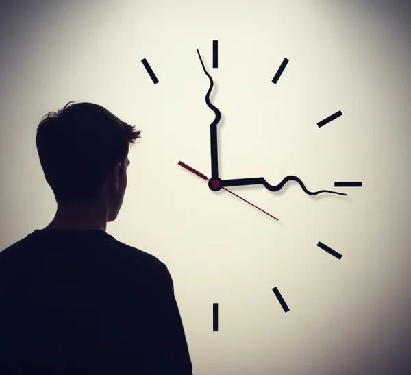 Person looking confused at a complex analog clock face.